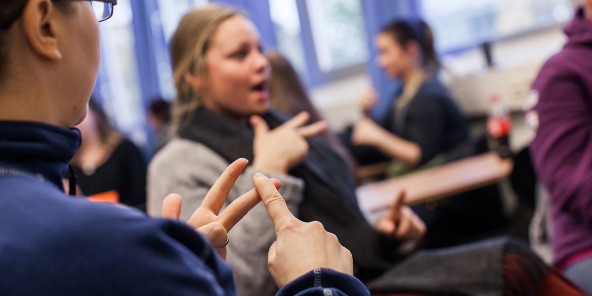 Studenter snakker tegnspråk i klasserom. Foto.