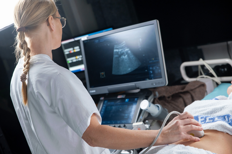 Kvinne som tester ultralyd på en pasient